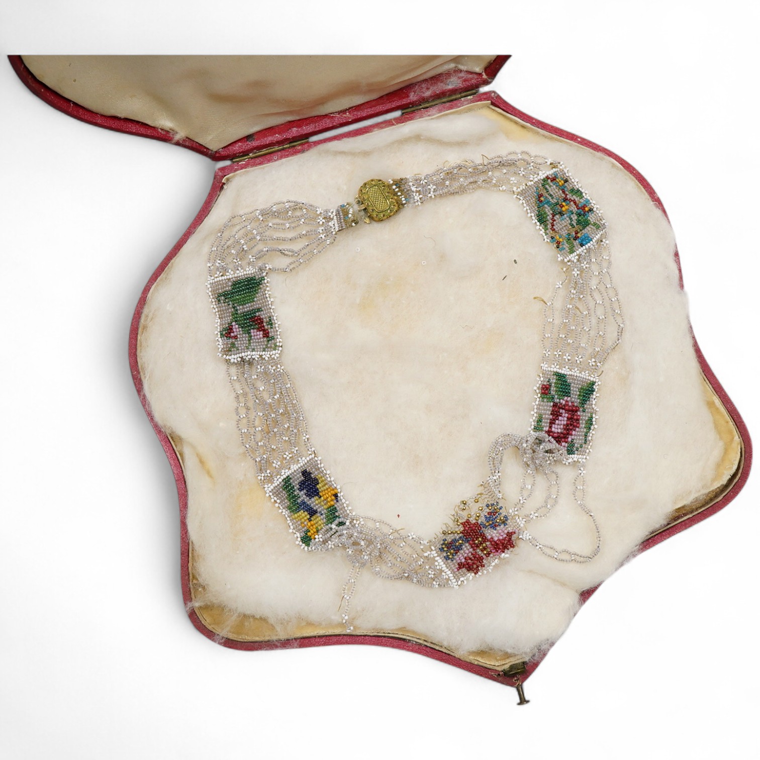 A glass bead necklace, early 19th century, intricately composed of woven glass beads depicting panels of butterflies and flowers, together with early 20th century correspondence from the Victorian & Albert Museum discuss